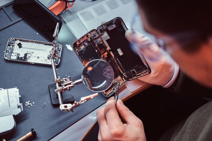 Technician repairing a phone under magnification